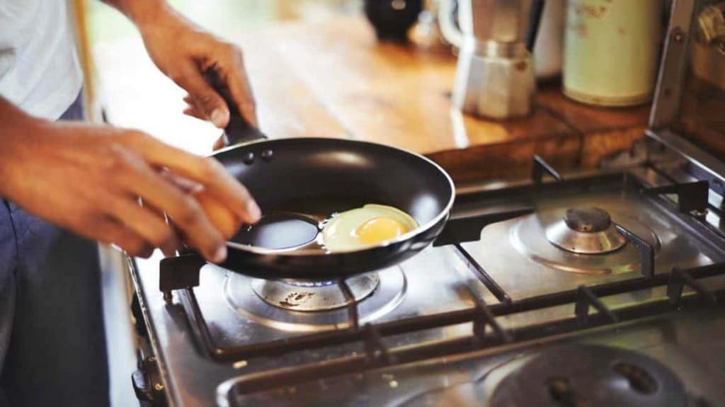 man cooking fried egg